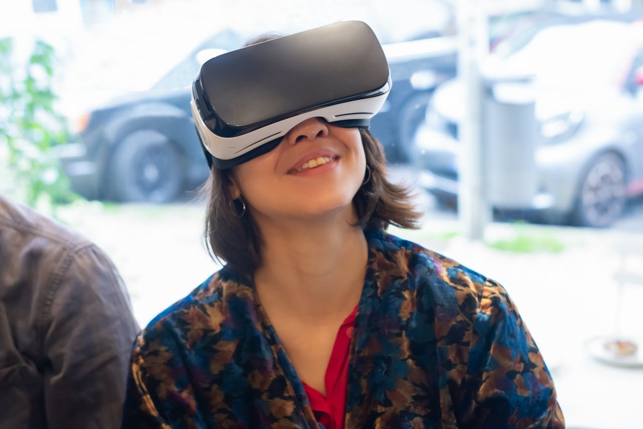 Smiling woman wearing VR goggles, immersed in a virtual world indoors.