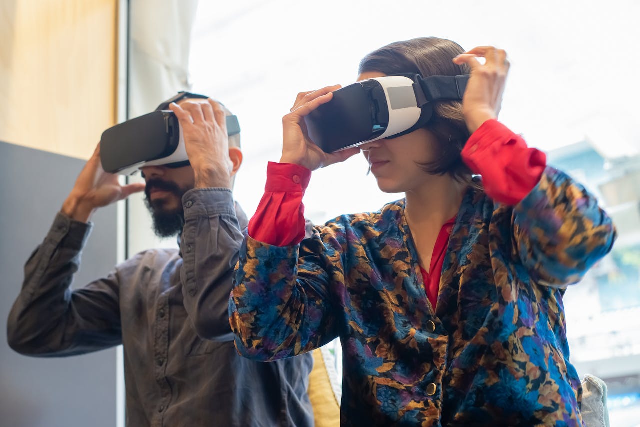 Two adults using virtual reality headsets indoors, experiencing immersive technology together.