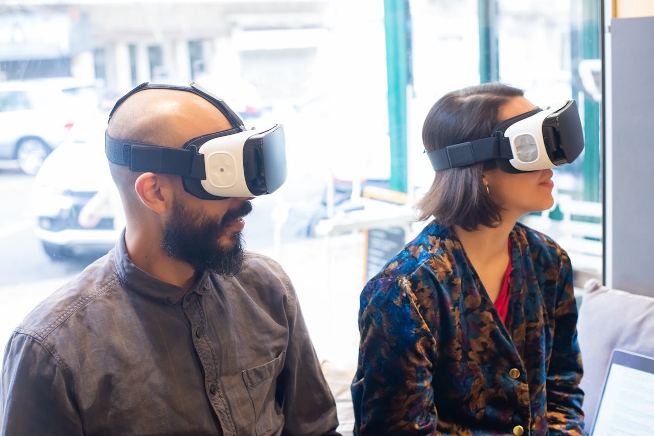 Two adults wearing VR headsets indoors, exploring virtual reality.